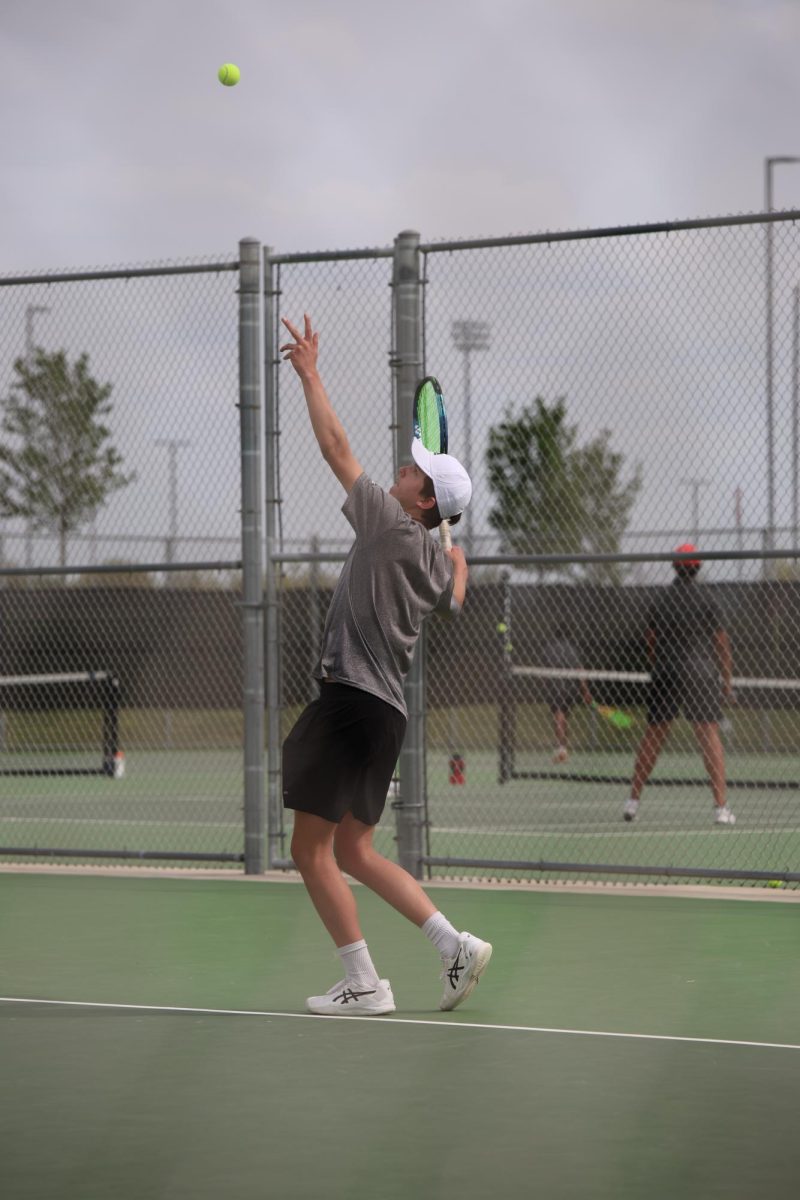 Ready to serve, senior Emmett Wirth tosses the ball up on April 15.