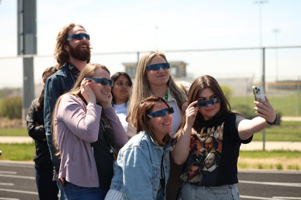 Smiling at the camera, ELA teachers Storm Shaw (back left), Corrine Simmons, (left), Erin Mormando (middle), Kinsey Binger (back right), and Emily Winters (front right) take a selfie with their solar eclipse glasses on. 