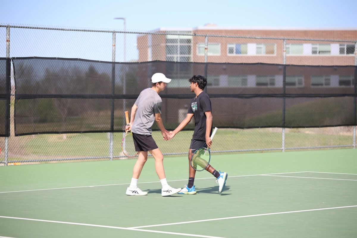 Hands together, doubles partners senior Emmett Wirth and junior Sanjay Rajkumar celebrate after winning the point on April 9.