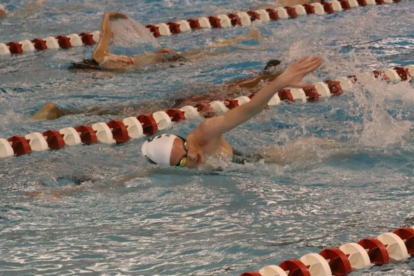 Completing a drill, freshman Ashlyn Bolyard warms up her arms for butterfly on April 5 during the swim meet against Blue Valley West. 