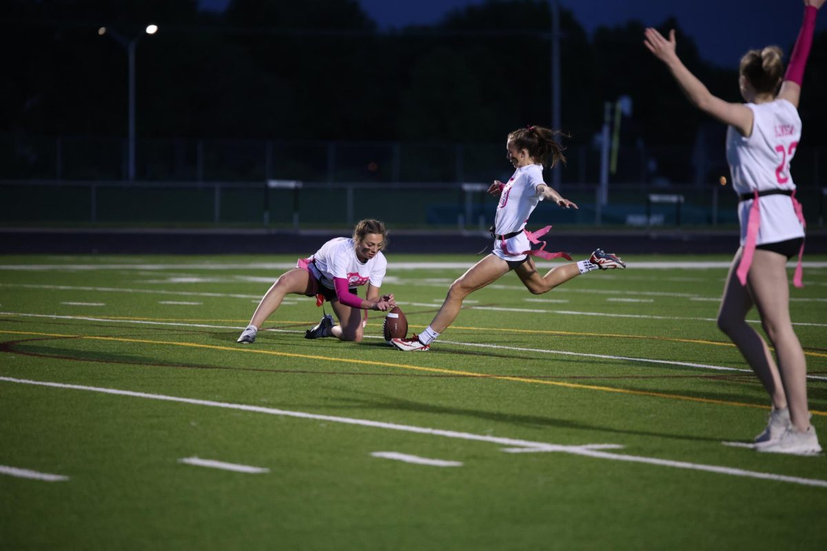 Arms out, junior Izzy Ross kicks a field goal on May 6. Junior Bragan Quinter held the ball for Ross during Powderpuff.