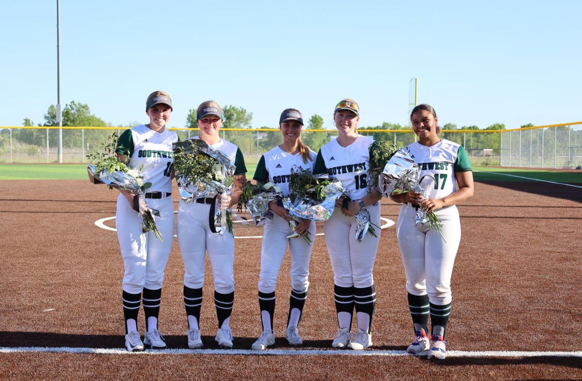 Holding their bouquets, seniors Riley Baber, Taylor Renzi, Bailey Weber, Meghan Hentschel and Kyndel Black pose for a photo together at the senior night doubleheader against Blue Valley West on May 7. In between games, seniors were recognized as they walked out on the field with their parents and underclassmen gave speeches about them. The end scores were 1-9 and 9-10.