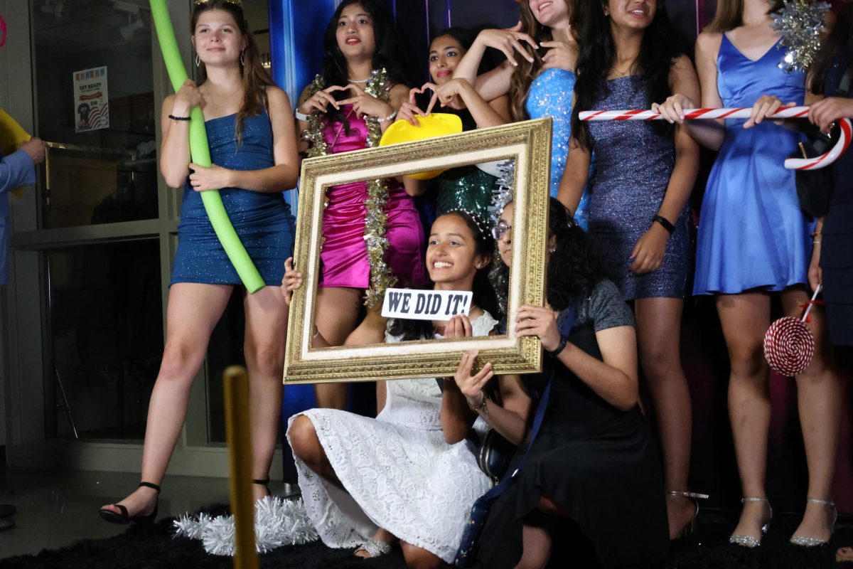 Posing for a picture, sophomores Prisha Bhandari and Taara Parthasarathy hold up a picture frame on Sept. 14.