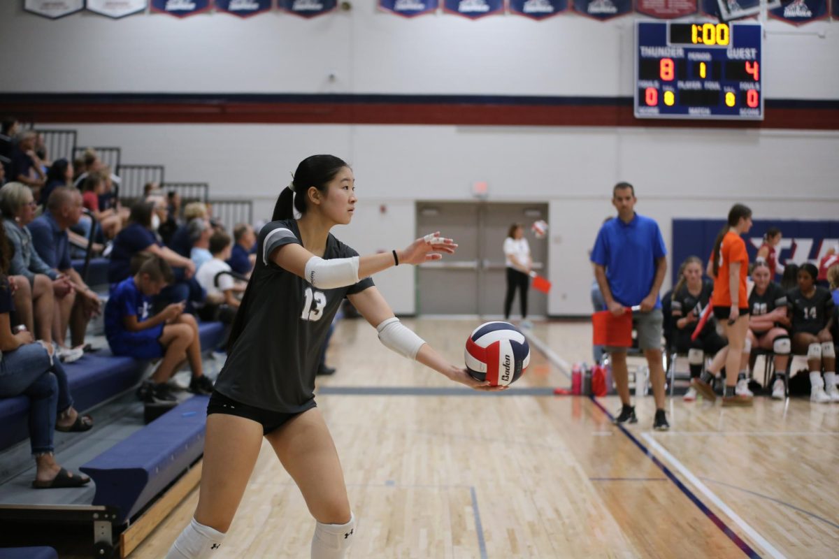 Junior Catlin Shao prepares to serve to ball to the other team at her volleyball game on Oct. 1.