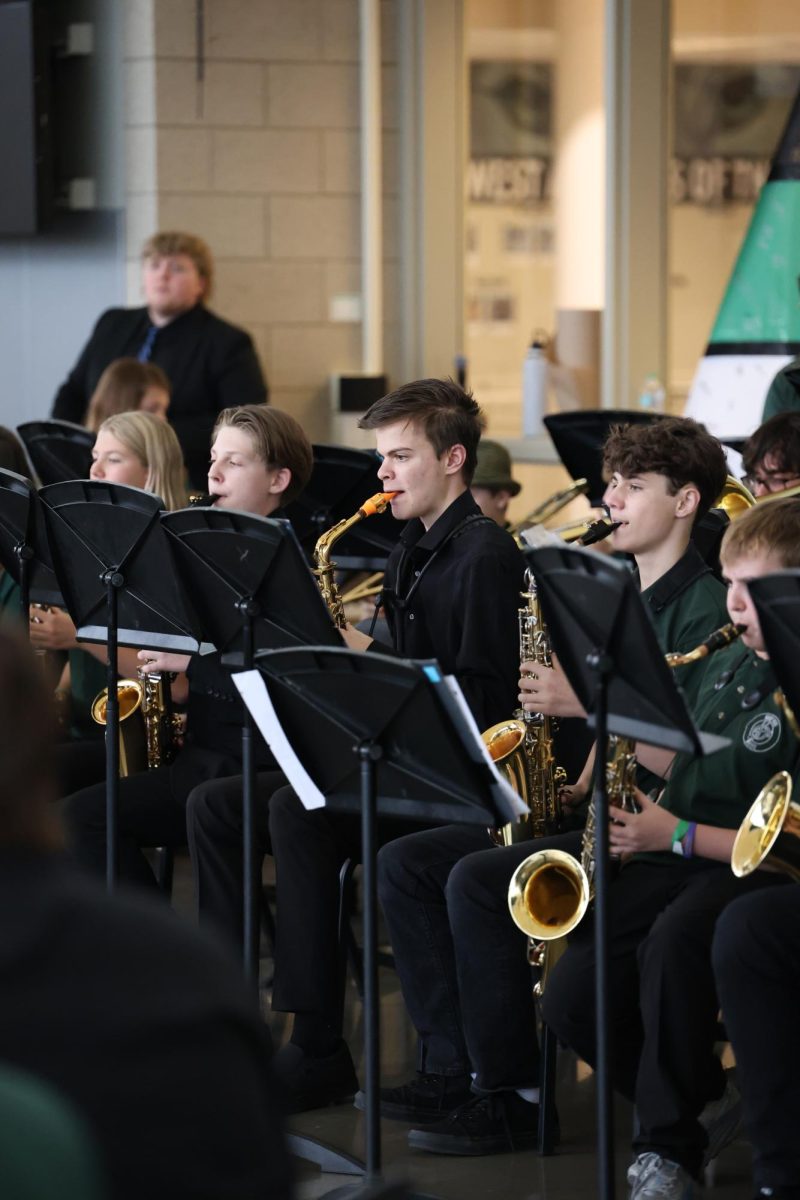 Playing with the middle school band, junior Derek Townsend plays saxophone at the Jazz Café on April 24.