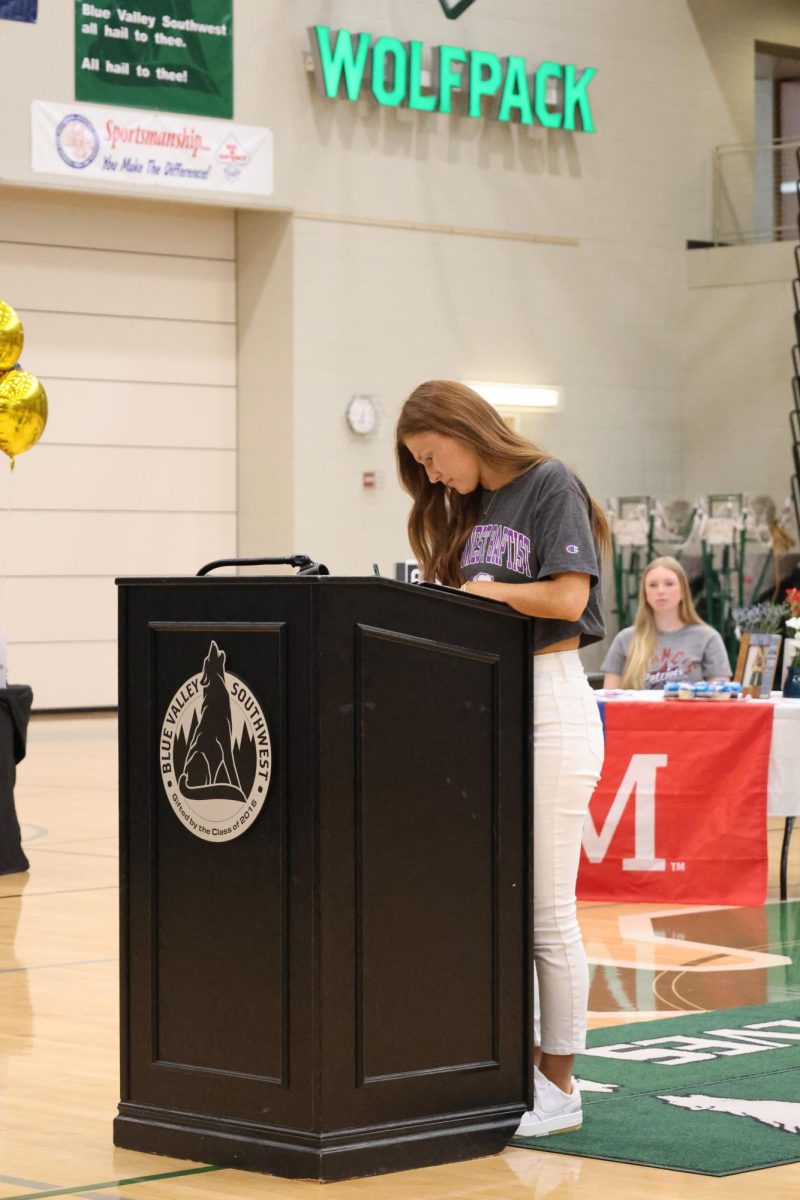 Pen in hand, Senior Jillian Herman reads the paper before she signs it
