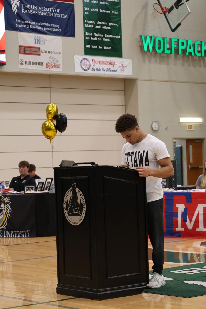 Looking down, the senior Jaelyn Sides looks to sign the paper