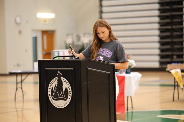Walking up to the podium, senior Jillian Hermann gets ready to sign her name.