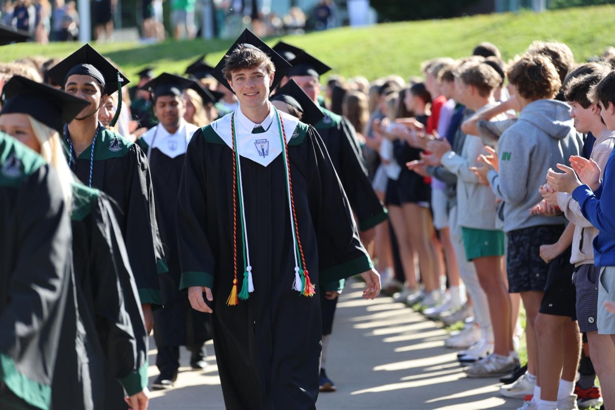 Cords on, Senior Ben LaCroix smiles big as he walks down the courtyard on May 16.