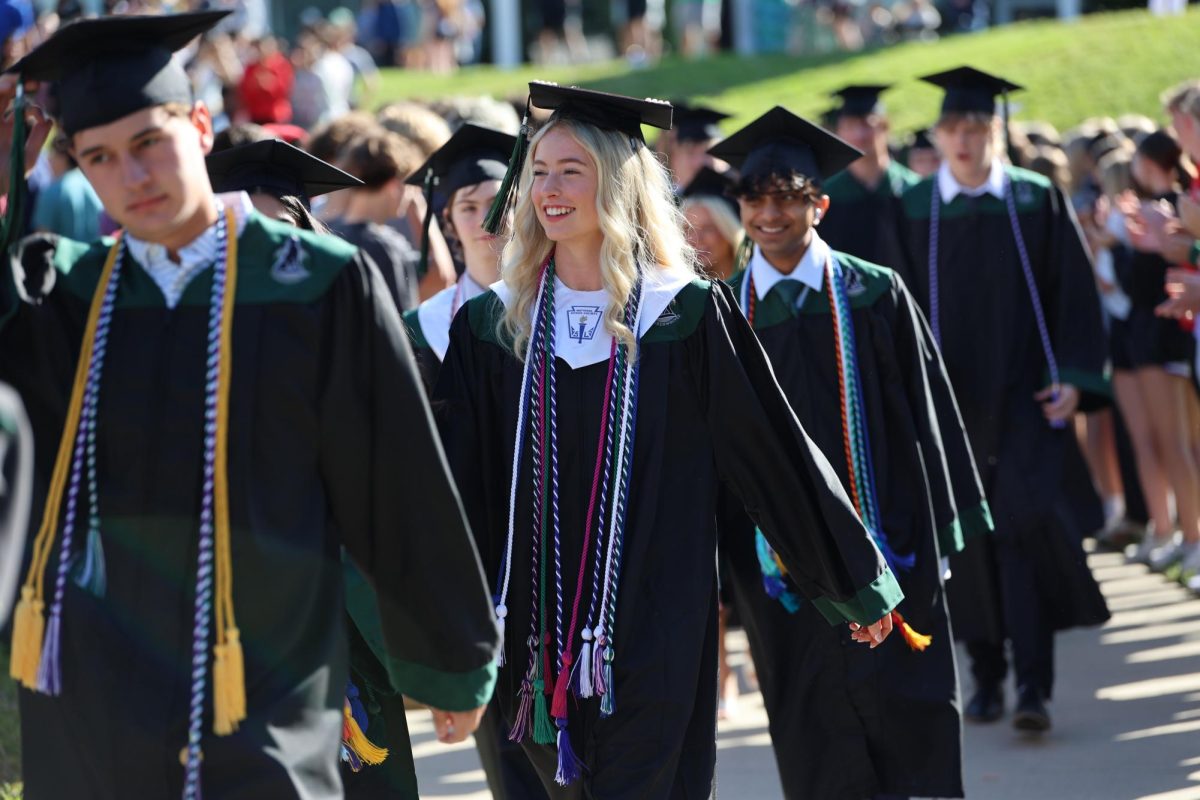 Mid Walk, Senior Olivia Payne smiles big as she is applaud by the school on May 16. 