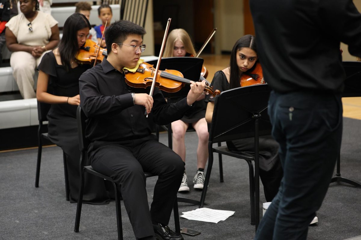 On Violin, Junior Caleb Park plays music with the Orchestra at Class Day on May 16. 