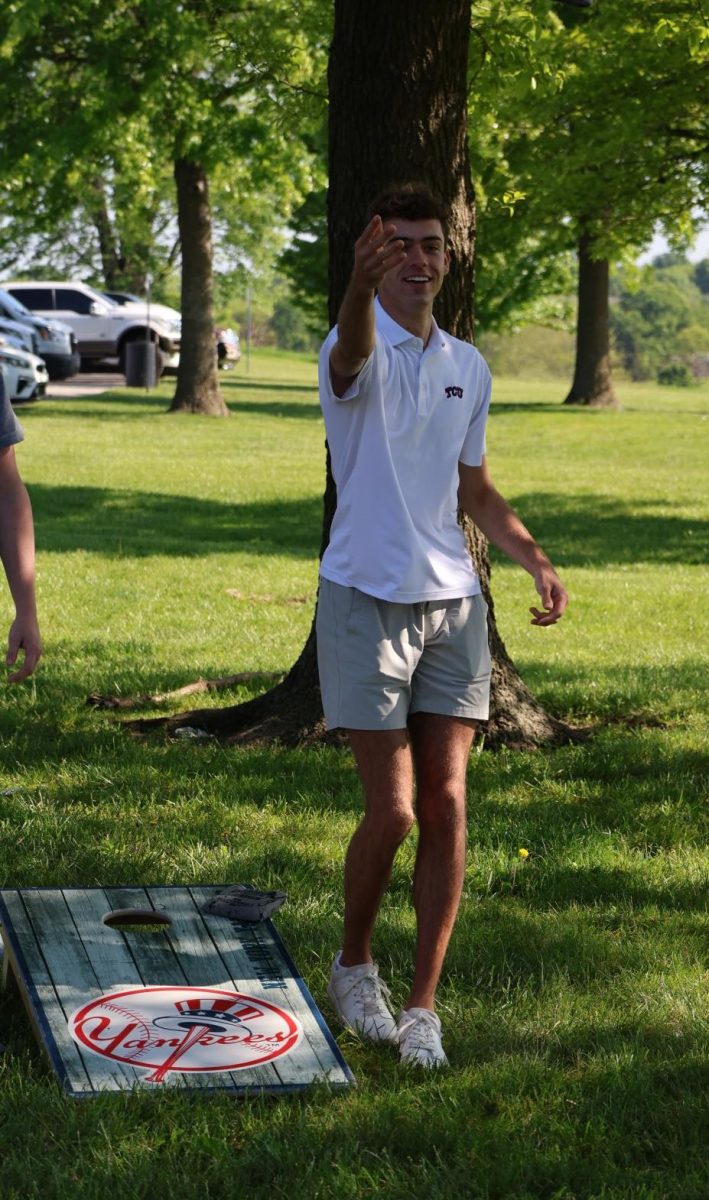 Tossing the beanbag, senior Alex Beelman plays a friendly game of cornhole with his classmates at the senior picnic on May 9.