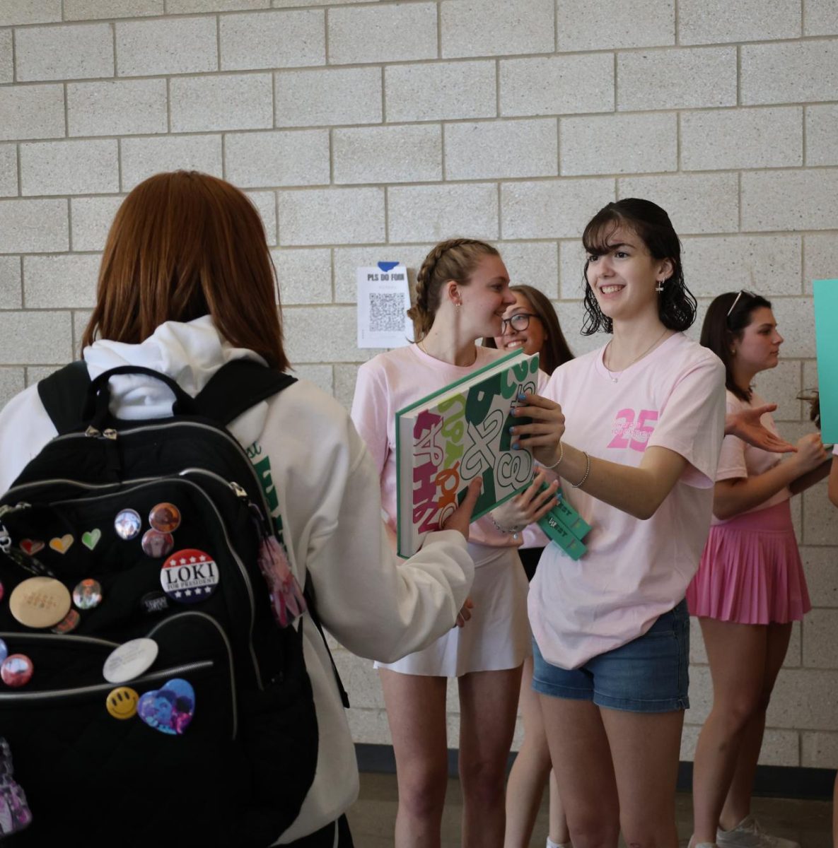Passing out yearbooks, junior Bella Bachand gives a yearbook out to a student during yearbook distribution day on May 9.