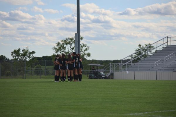 Varsity team huddles together before the start of the game.