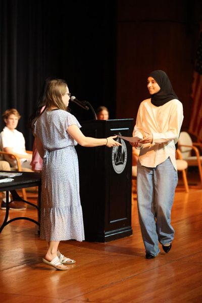 Receiving a certificate, junior Zayna Ahmed gets inducted into Math National Honor Society on May 1.