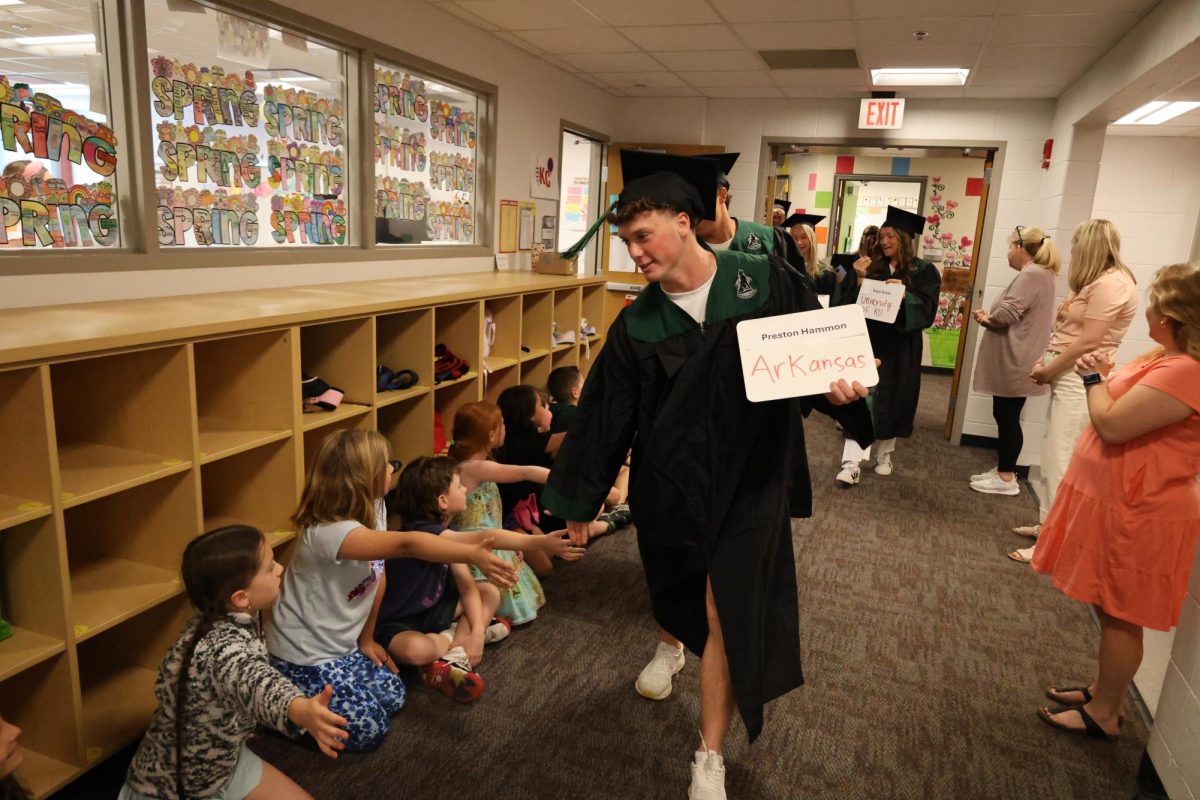 Hand stretched, senior Preston Hammon walks through Morse Elementary halls, high fiving the kids. 