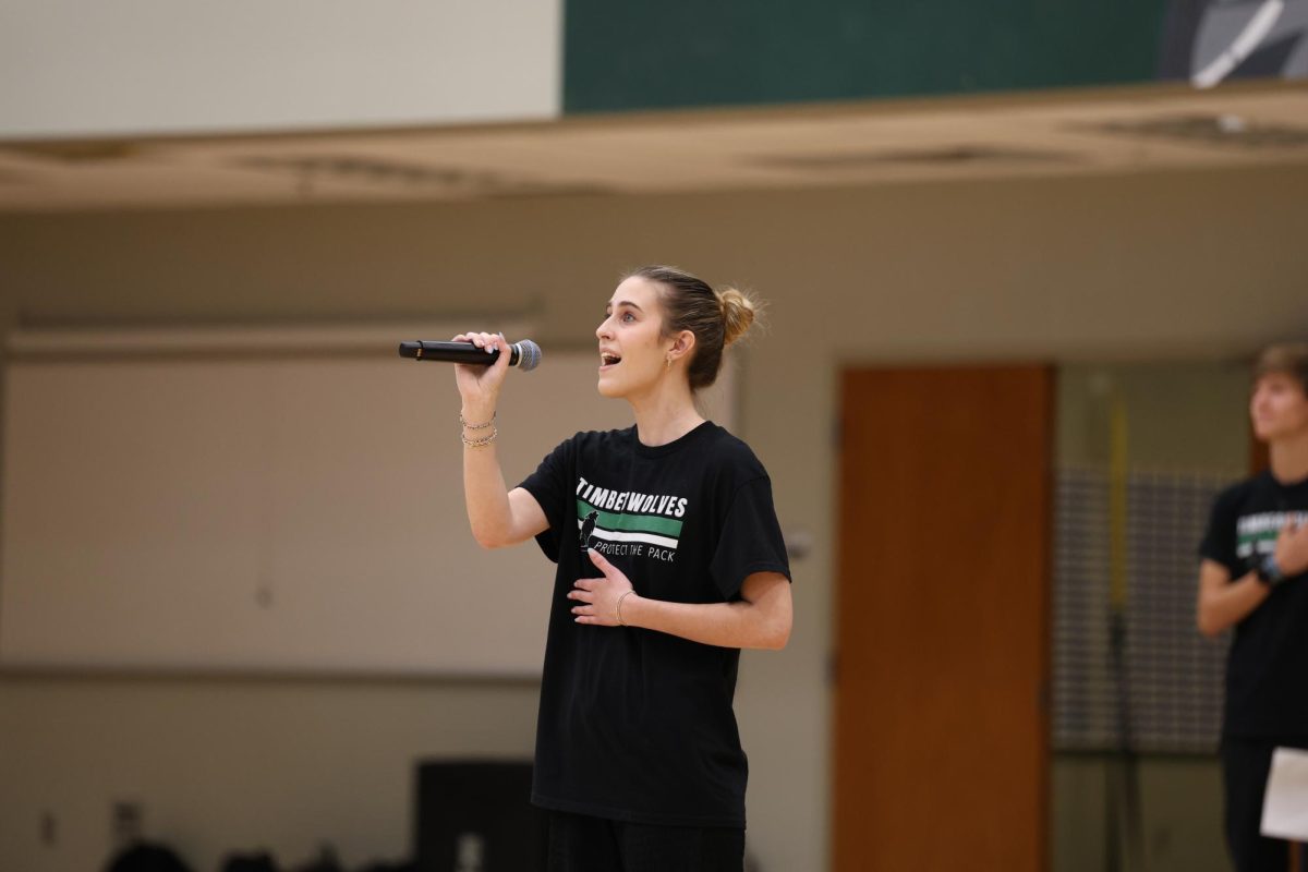 Junior Charlie Carlisle starts off the assembly by singing the national anthem. 