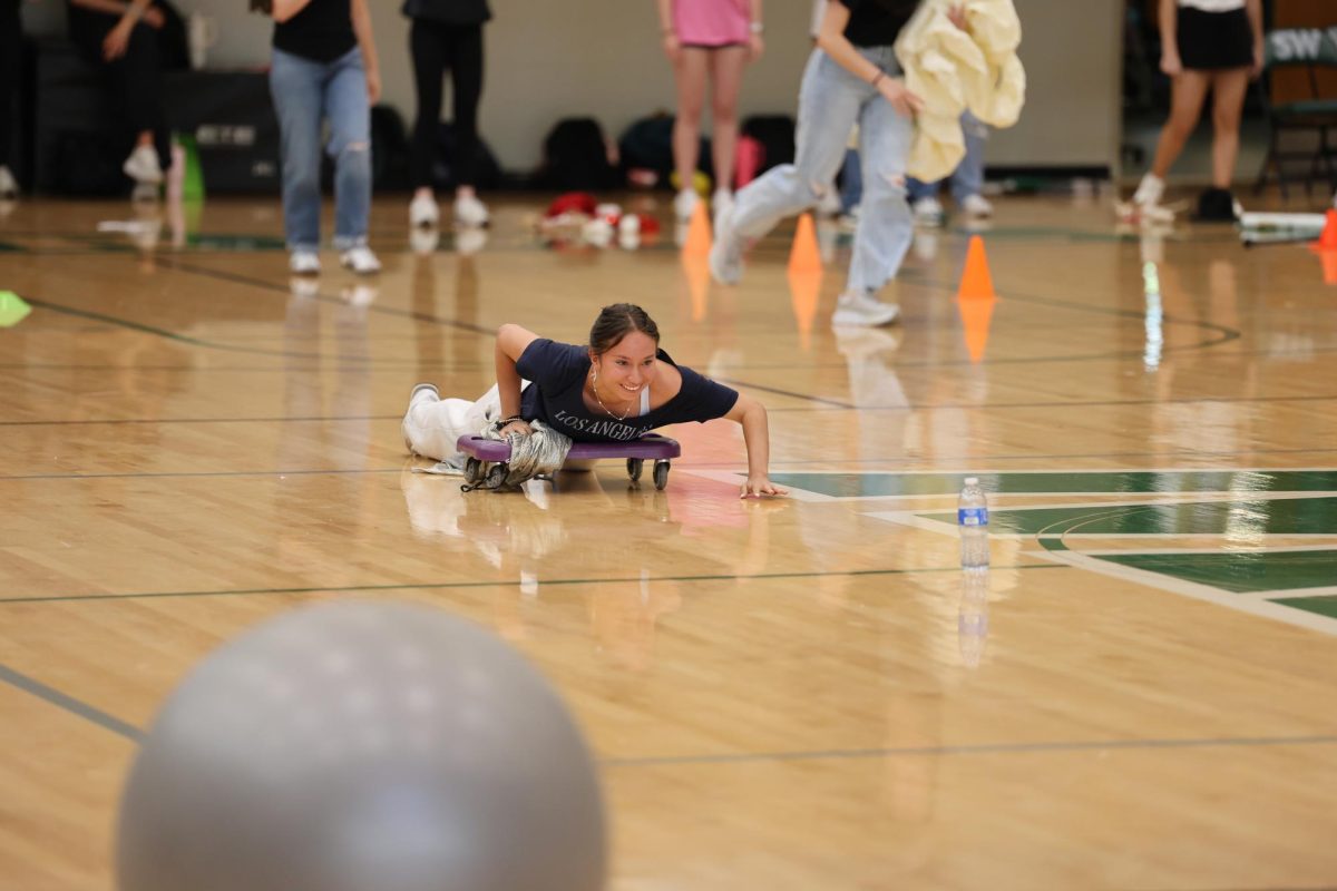Sophomore Kylie Reyes rides the scooter during the assembly game. 
