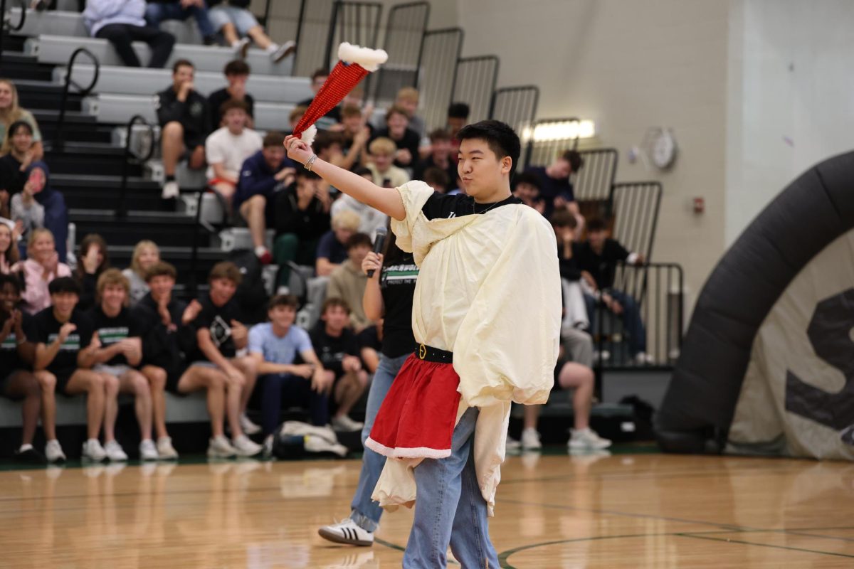 Junior Caleb Park swings his hat walking down the runway for the assembly game. 