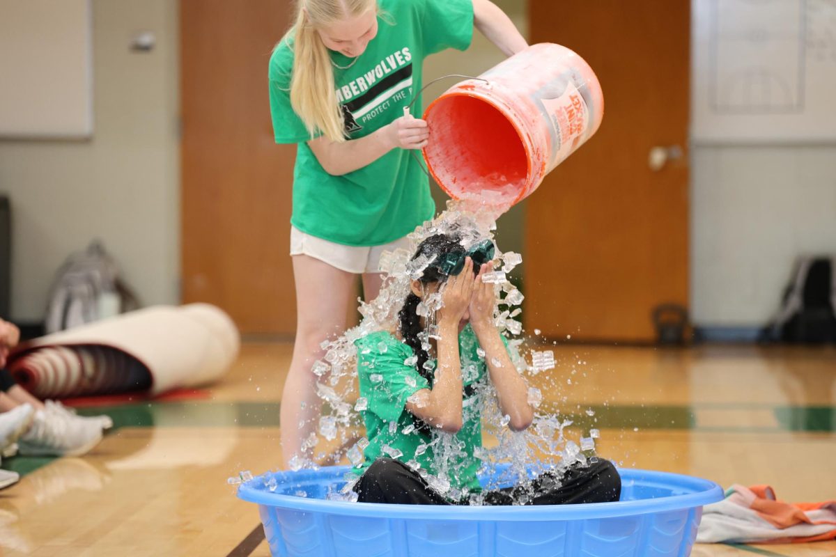 Freshman Raina Hilaly gets ice poured on her for the ice bucket challenge during their class skit. 