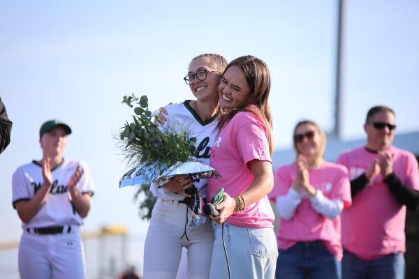 Junior Arden Harms embraces senior Mara Somogye after giving a speech during senior night. 
