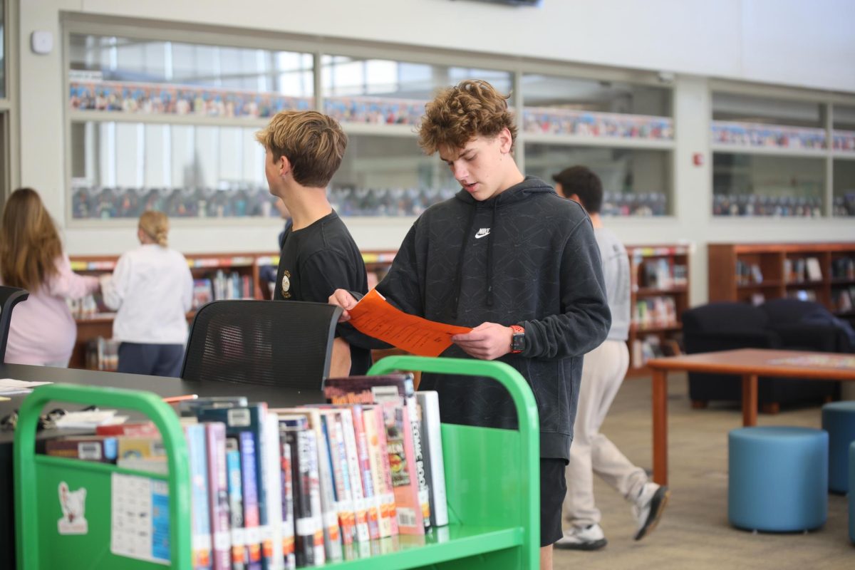 Staring at his paper, freshman Maksim Albright looks over his answers during the Trivia Game on Oct. 30.