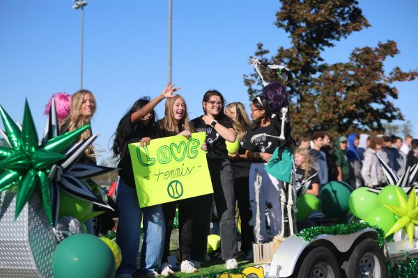 Sign in their hands, seniors Joanna Suku, Annie Arthur and Abby Shoikhet smile in the Homecoming parade on Oct. 21.