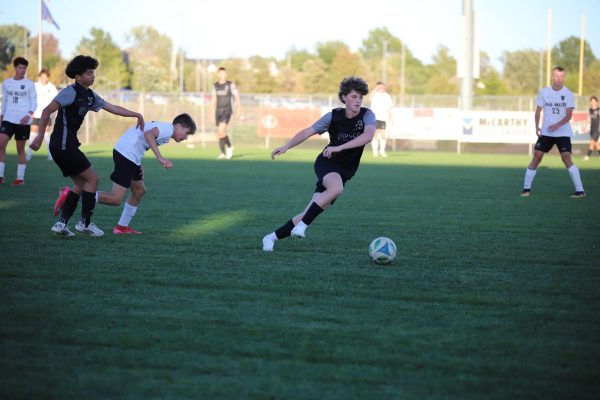 Running to the ball, sophomore Eli Wilkinson works to gain possession during the JV soccer game on Oct. 21.