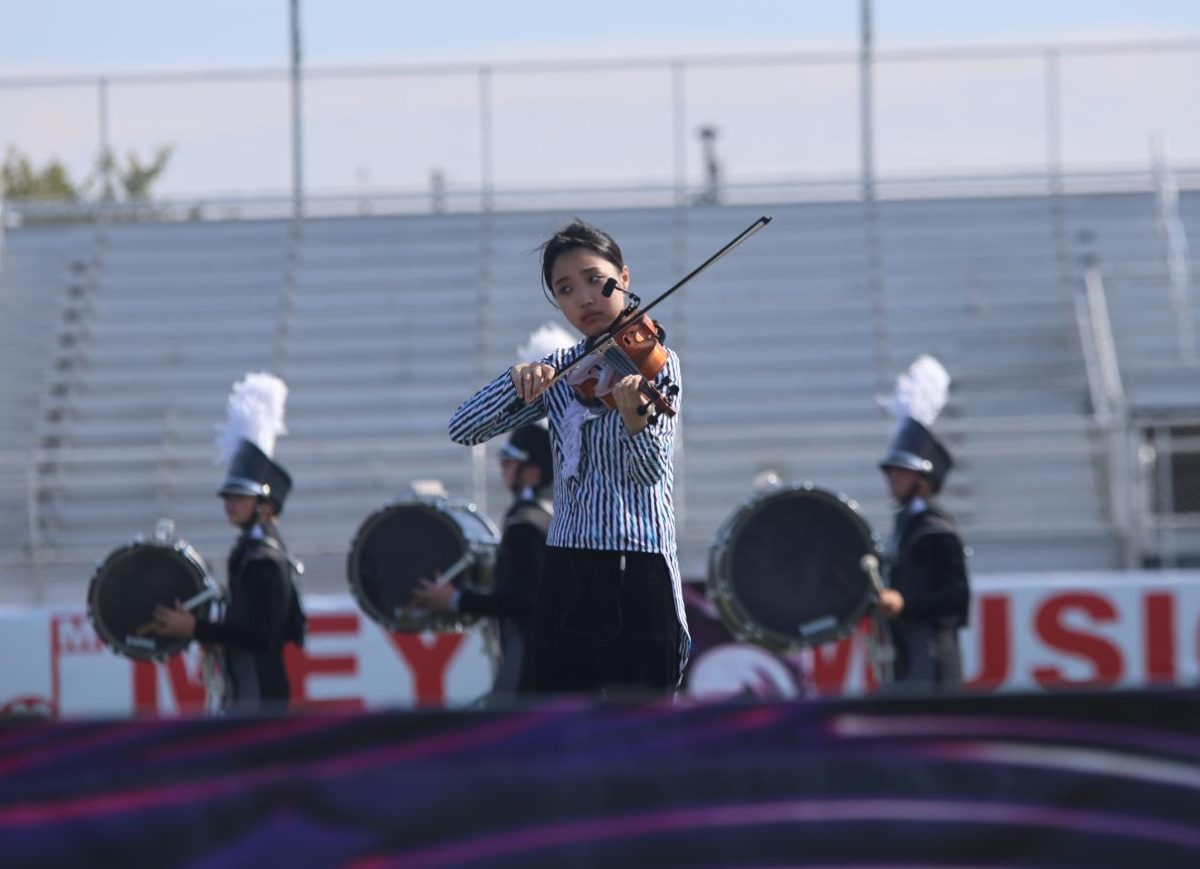 Bow on her violin, senior Alexis Chang performs at the Olathe Marching Invitational on Oct 11. 