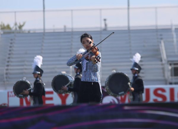 Bow on her violin, senior Alexis Chang performs at the Olathe Marching Invitational on Oct 11. 