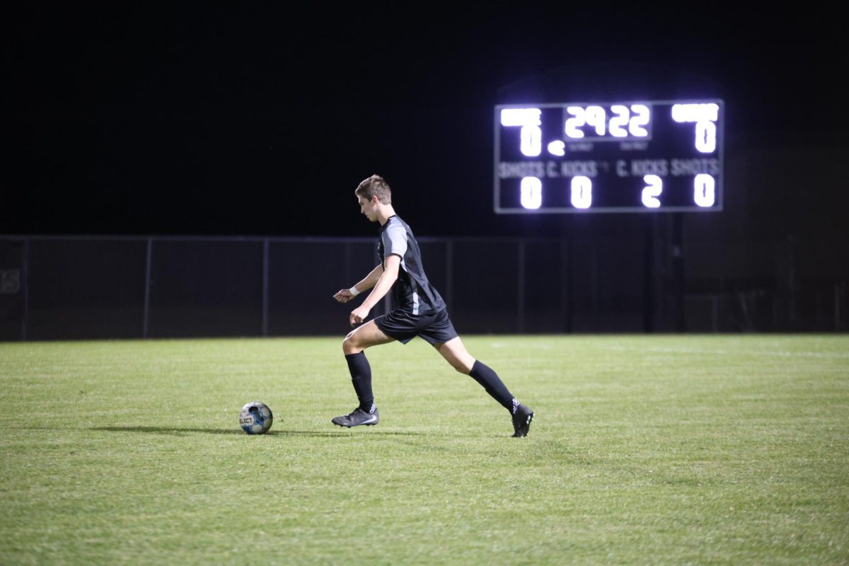 Focused on the ball, senior Wesley Abraham gets ready to kick the ball during the quarterfinal game against Piper on Nov. 3.