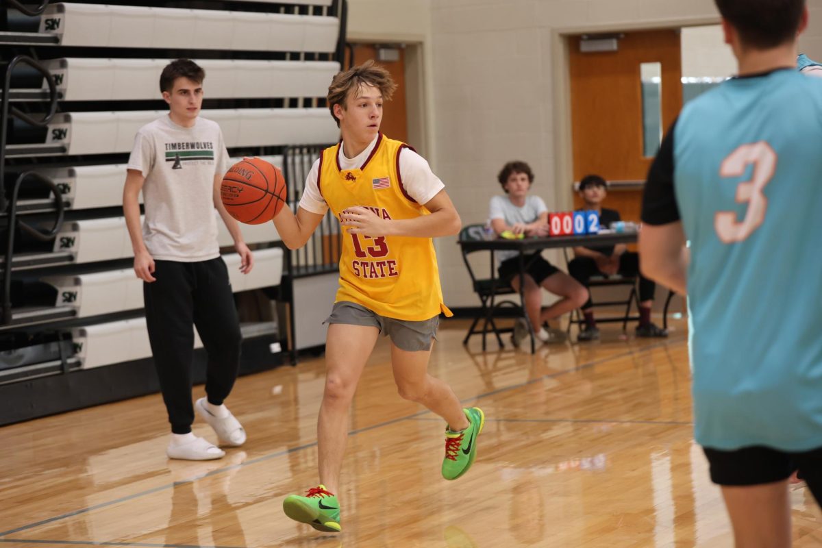 Ball in hand, junior Houston Duckworth dribbles forward for a shot at Hoops for Hope on Nov. 12.