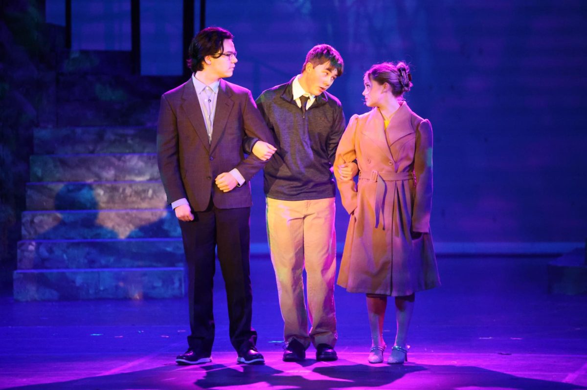 Arms linked, senior Sebastian Salinas and juniors Ryder Smith and Izzy Beeton perform on Nov. 13 in the musical teaser. 