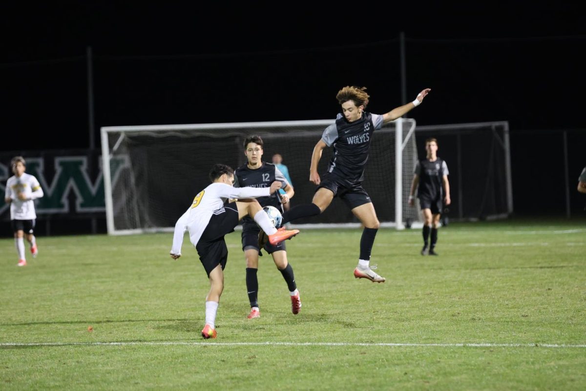 In the air, senior Gavin Gryp attempts to kick the ball on Nov. 5 in the soccer game against Newton.