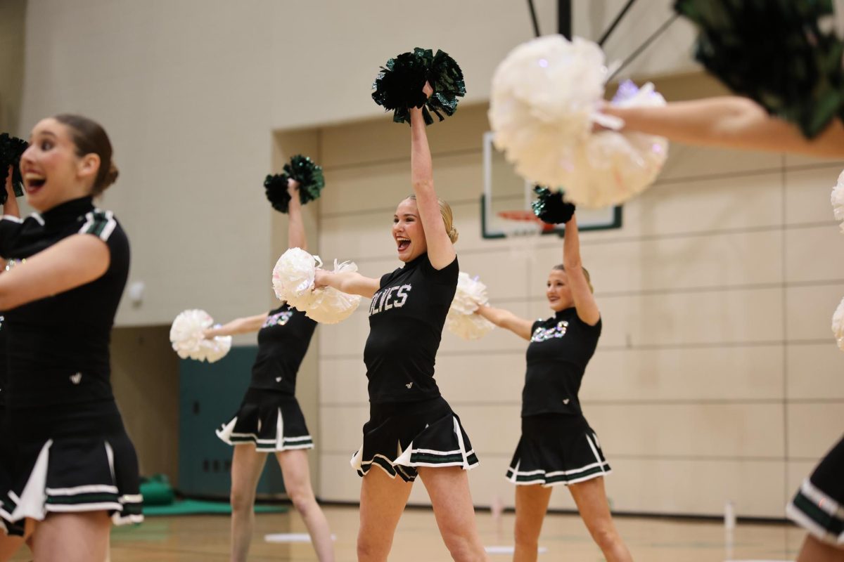 Arms out, freshman Tenley Hutton holds out her poms during the Glitter Girls’ State showcase on Nov. 18.