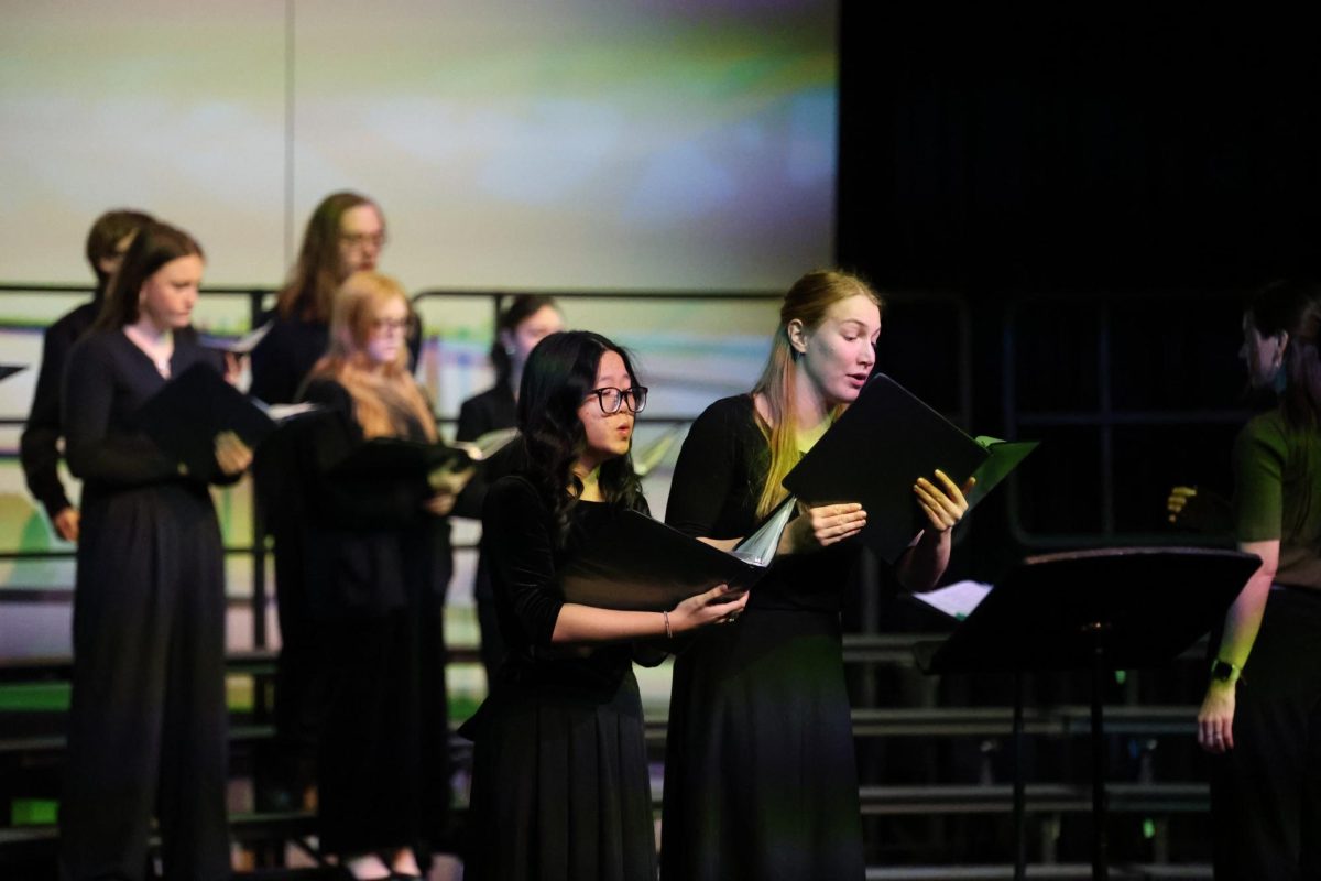 Standing together, junior Diana Wang and sophomore Rachel Pishny sing at a choir concert on Dec. 4.