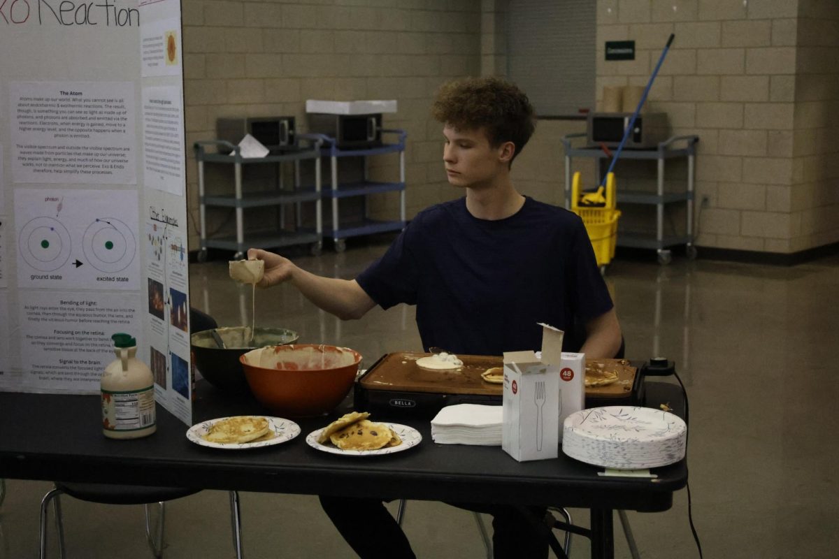 Ladel in hand, Grade Name Name makes pancakes at the STEM Fair on Dec 3.