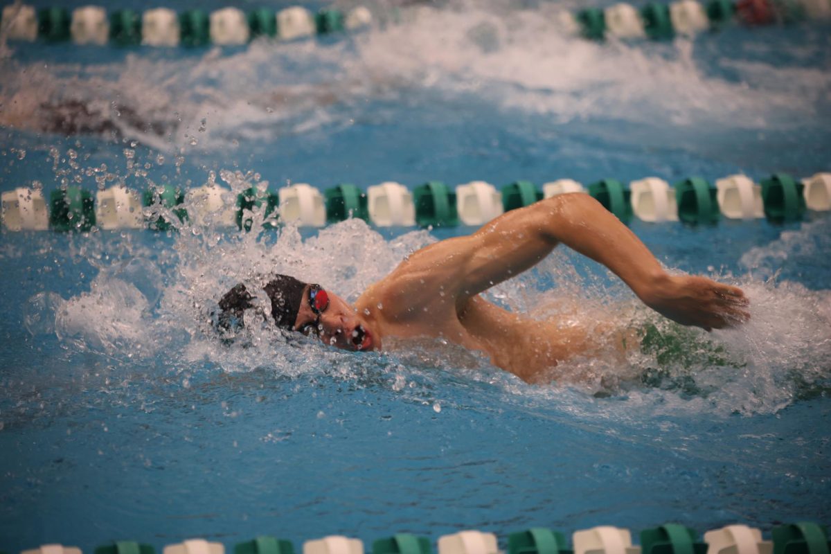 Mid-stroke, junior Nicholas Heinen moves his arm at the boys swim meet on Jan. 20.