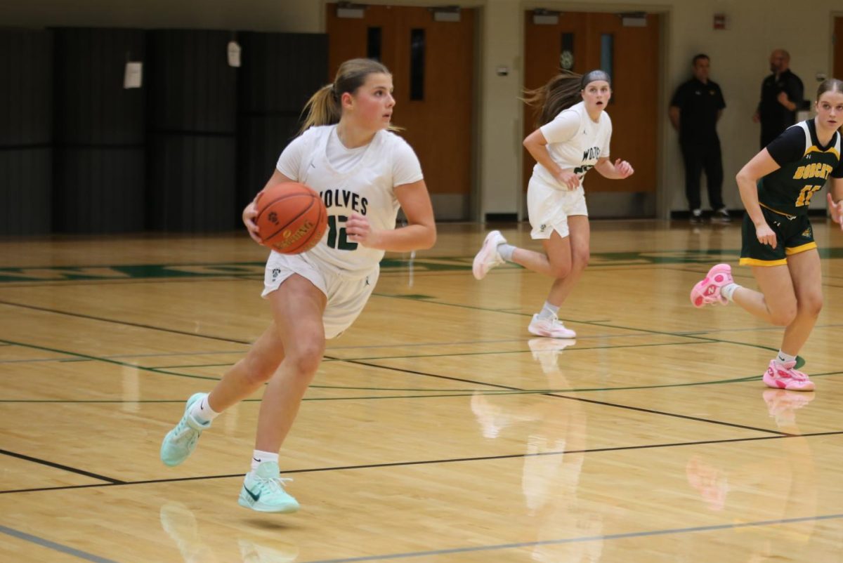 Running, senior Mia Hansen dribbles the ball down the court during a varsity girls basketball game on Jan. 8.