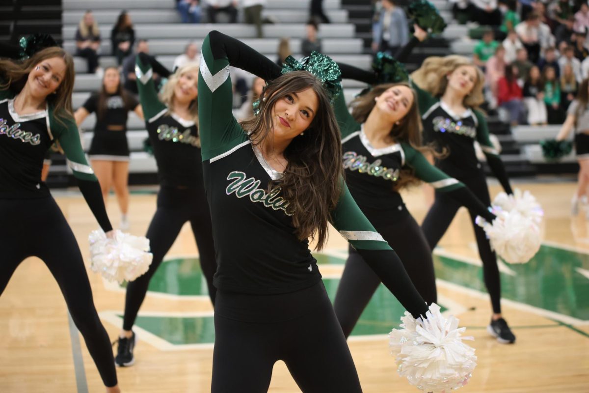 Head tilted, senior Abby Finke performs with the Glitter Girls during the winter sports assembly on Jan. 8.
