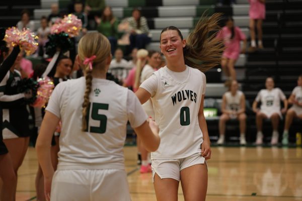 Running up, sophomore Macy Hansen gets ready to play against Blue Valley on Feb. 13.