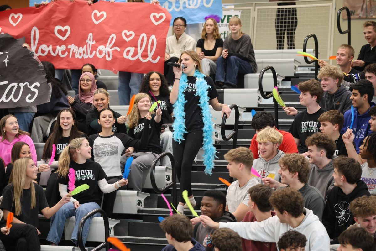 Walking down the stairs, junior Brynn Carmichael sings in the junior skit at the assembly on Feb. 5.