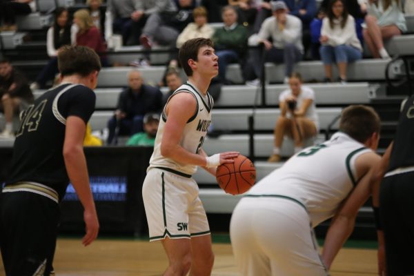 Eyes on the basket, senior Wesley Abraham shots the ball during the boys varsity basketball game on Feb 13.
