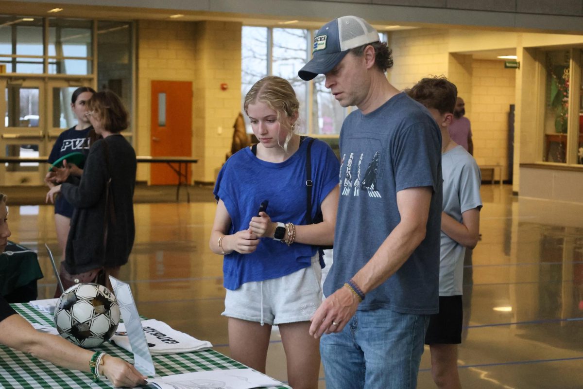 At the soccer table, an eighth grade student learns about the program at Meet the Pack Night on March 31.