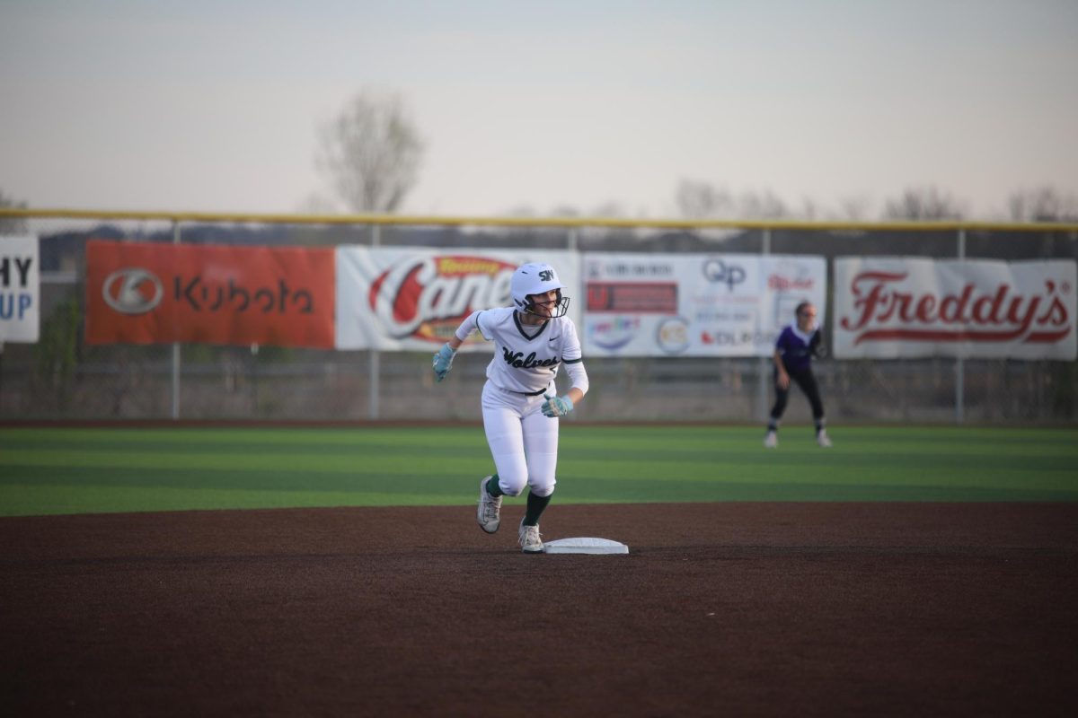 Ready to run, senior Melia Peters steals third base at the varsity softball game on April 7.