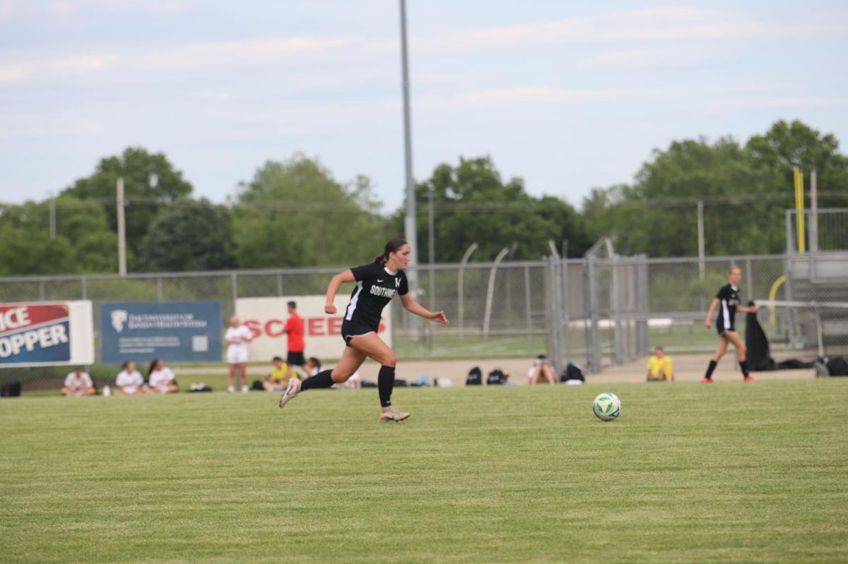 Dribbling the ball, junior Lily Haskins takes the ball toward the goal on May 12.