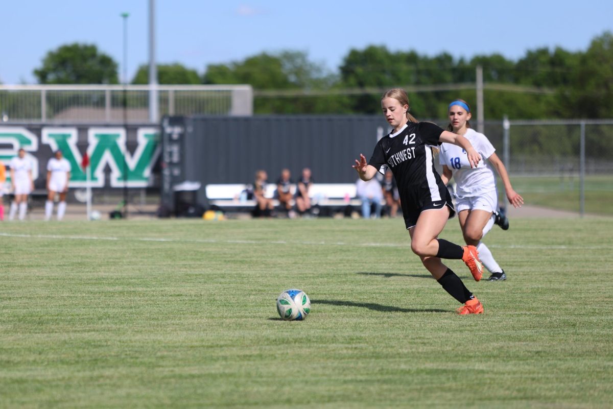 Mid-step, freshman Addi Rasmus drives to the other side of the field during a game against Leavenworth on May 7.