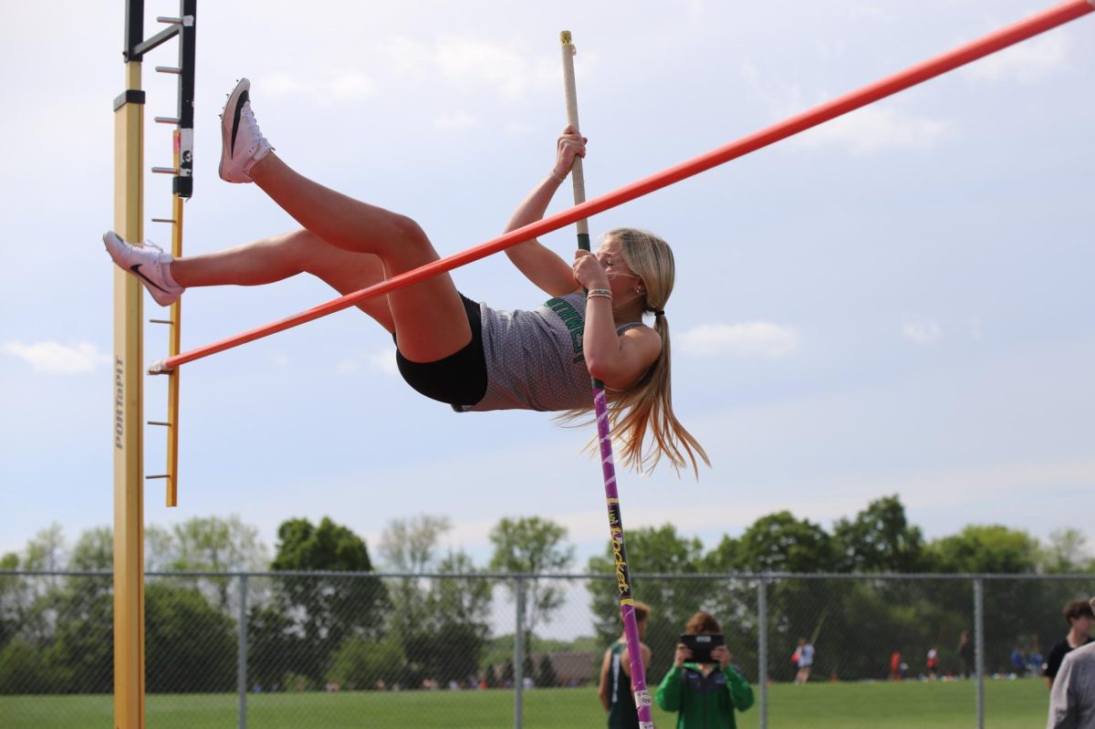 In the air, freshman Nya Deshler pole vaults.