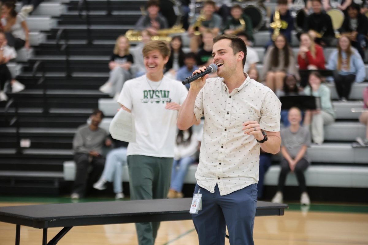 Passionately, business teacher Nick O'Keefe sings for the game at the spring assembly on April 30.