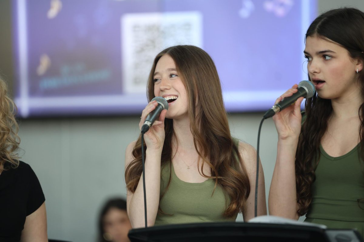 Looking at classmate, senior Madeline Watkins glances over shoulder at her partner during their quartet. Watkins had multiple solos during this performance that took place on April 6. 